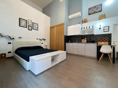 a bedroom with a large bed and a kitchen at Loft Lumineux à Trastevere in Rome