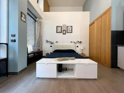 a bedroom with a bed and a white desk at Loft Lumineux à Trastevere in Rome
