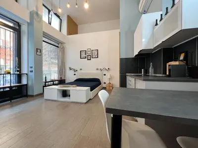 a large room with a bed and a kitchen at Loft Lumineux à Trastevere in Rome