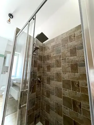 a bathroom with a shower with a glass door at Numa House in Rome