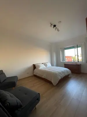 a bedroom with a bed and a couch and a window at Numa House in Rome