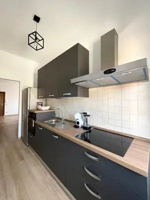 a kitchen with black cabinets and a counter top at Numa House in Rome