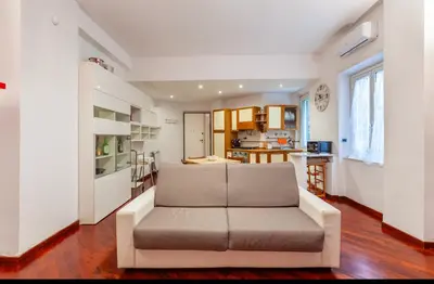 a living room with a couch and a kitchen at Vacanze Romane con giardino in Rome