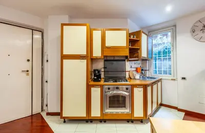 a kitchen with wooden cabinets and a stove at Vacanze Romane con giardino in Rome