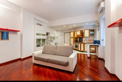 a living room with a couch and a kitchen at Vacanze Romane con giardino in Rome