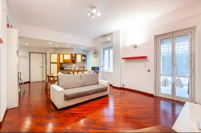 a living room with a couch and a kitchen at Vacanze Romane con giardino in Rome