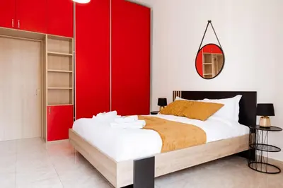 a bedroom with a large bed with red cabinets at Maffis House in Rome