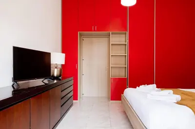 a bedroom with red walls and a bed and a tv at Maffis House in Rome