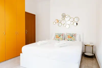 a bedroom with a large white bed with orange cabinets at Maffis House in Rome