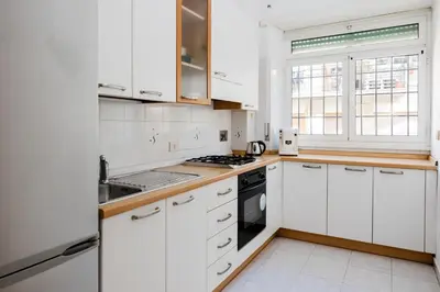 a white kitchen with white cabinets and appliances at Maffis House in Rome