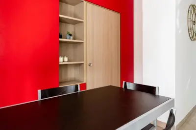 a dining room with a black table and red accent wall at Maffis House in Rome