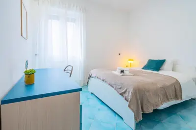 a bedroom with a bed and a blue desk at Domus Blu Aurelia in Rome