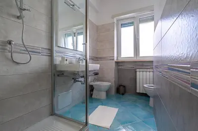 a bathroom with a shower and a toilet and a sink at Domus Blu Aurelia in Rome