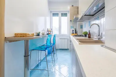 a kitchen with blue floors and a counter with stools at Domus Blu Aurelia in Rome