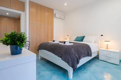 a bedroom with a large white bed and a plant at Domus Blu Aurelia in Rome