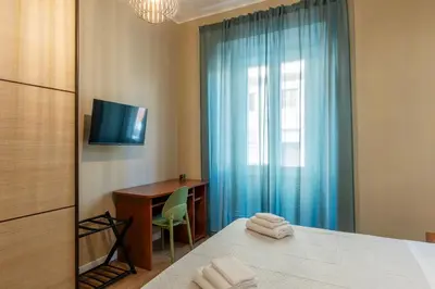 a bedroom with a bed and a desk and a television at GuestHost - San Giovanni Laterano Apartment in Rome
