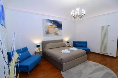 a living room with a couch and two blue chairs at Elegant Suite Colosseo in Rome