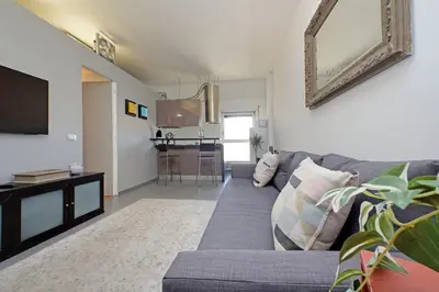 a living room with a gray couch and a tv at Manzoni in Rome
