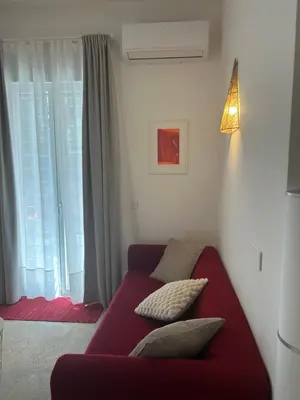 a red couch in a living room with a window at Trecento7Flat in Rome