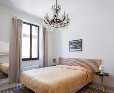 a bedroom with a large bed and a chandelier at Casa Domenica in Rome
