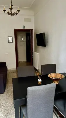 a living room with a table and chairs and a television at Casa Domenica in Rome