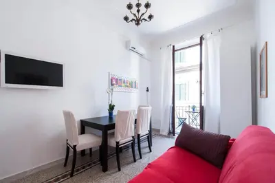 a living room with a red couch and a table at Casa Domenica in Rome