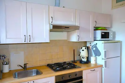 a kitchen with white cabinets and a sink and a stove at Gianicolo Trastevere Exclusive Apartments in Rome