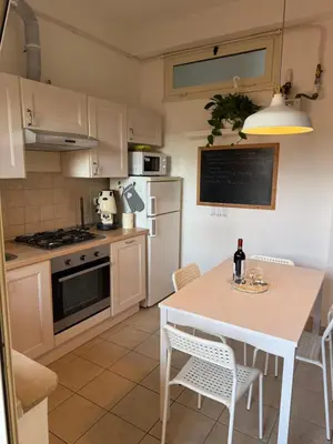 a kitchen with a white table and a white refrigerator at Gianicolo Trastevere Exclusive Apartments in Rome