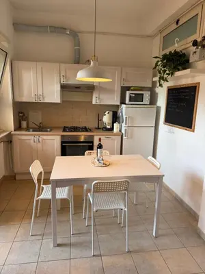 a kitchen with a table and chairs and a refrigerator at Gianicolo Trastevere Exclusive Apartments in Rome