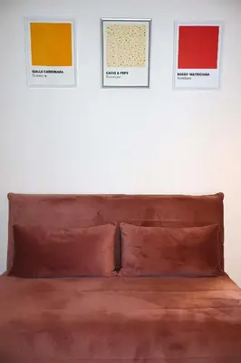 a bed in a room with three pictures on the wall at Gianicolo Trastevere Exclusive Apartments in Rome