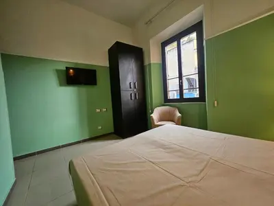 a bedroom with a bed with green walls and a window at San Lorenzo Accommodation One in Rome