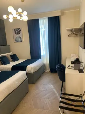 a hotel room with two beds and a desk at Esquilino rooms in Rome