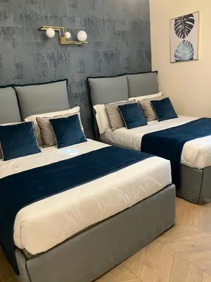 two beds in a room with blue pillows on them at Esquilino rooms in Rome