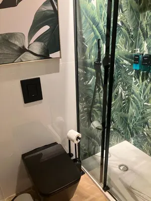 a bathroom with a black toilet and a shower at Esquilino rooms in Rome