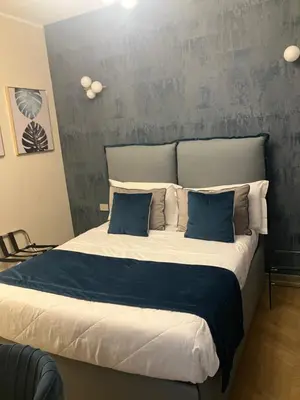 a bedroom with a large bed with blue pillows at Esquilino rooms in Rome