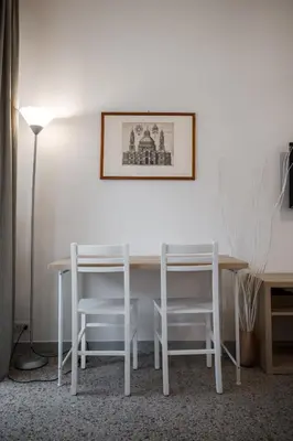 a white table and chairs in a room with a lamp at Domus Valle Aurelia - Vaticano - Metro Linea A in Rome