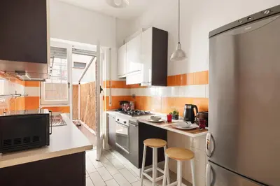 a kitchen with a stainless steel refrigerator and stools at Monteverde Private Terrace in Rome