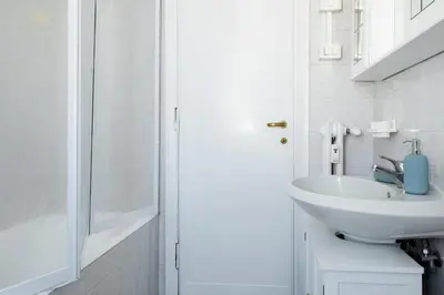 a white bathroom with a sink and a mirror at AnnaMarco Apartment in Rome