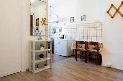 a kitchen with white cabinets and a table and chairs at AnnaMarco Apartment in Rome