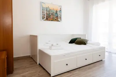 a white bed in a room with a painting on the wall at AnnaMarco Apartment in Rome