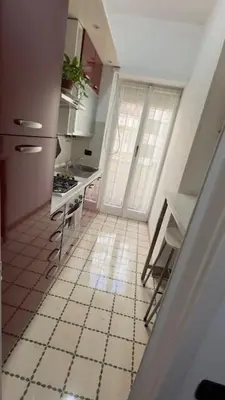 a kitchen with a white tiled floor and a window at Civico 10 Home in Rome