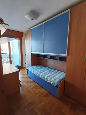 a bedroom with a bed with a large blue headboard at F&F Rome Apartment - 2 Bedrooms Aurelio Boccea in Rome