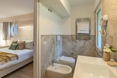 a bathroom with a bed and a sink and a toilet at 94Rooms Roma Nord - Flaminia in Rome