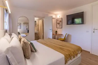 a bedroom with a large bed with a television on the wall at 94Rooms Roma Nord - Flaminia in Rome