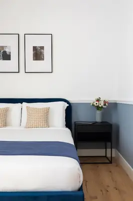 a bedroom with a blue and white bed and a table at Palomba Boutique Apartment in Rome