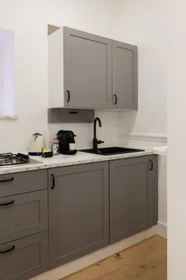 a kitchen with white cabinets and a sink at Palomba Boutique Apartment in Rome