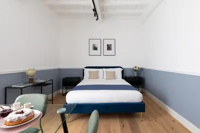 a bedroom with a bed and a table with a plate of food at Palomba Boutique Apartment in Rome