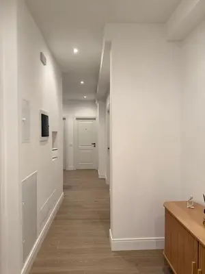 an empty hallway with white walls and wooden floors at Vita Lux Vatican Suites in Rome