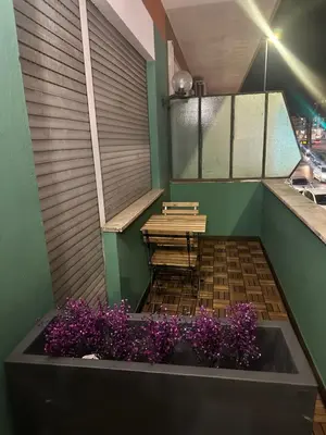 a small balcony with a table and purple flowers at Vita Lux Vatican Suites in Rome
