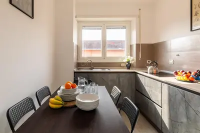 a kitchen with a table with plates and fruit on it at Vittoria C Elegant Apt Near Vatican & Dome View in Rome